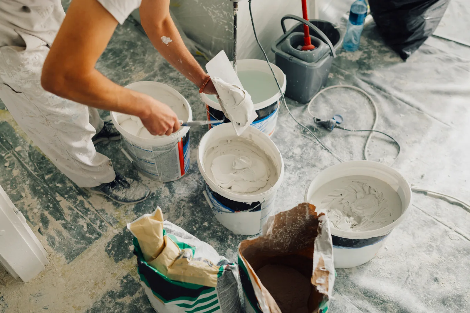 Cubos de plaste y herramientas preparados para alisar una pared